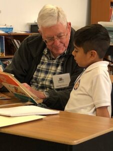 An old man reading to a young boy