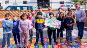 Sheena Wilton and students showing the mural they made